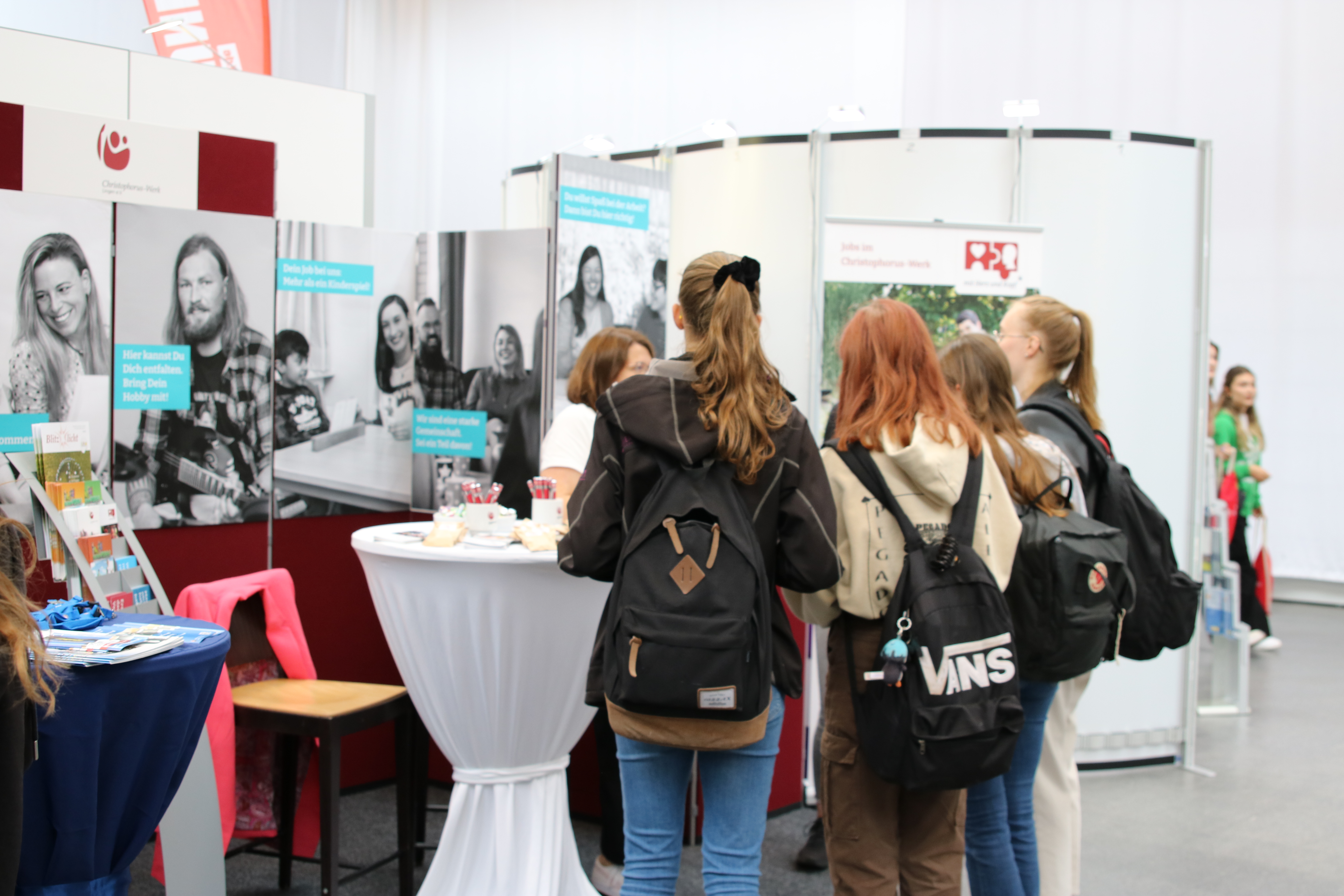 Junge Menschen lassen sich am Messestand des Christophorus-Werkes Lingen beraten.